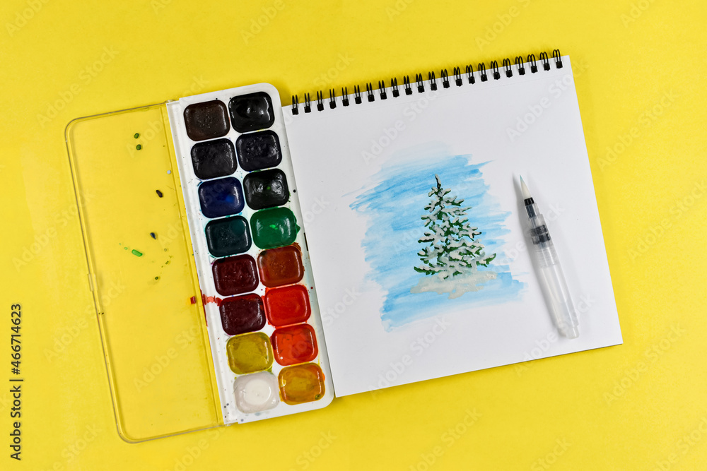 水彩画，覆盖着蓬松积雪的年轻绿色圣诞树，黄纸相册