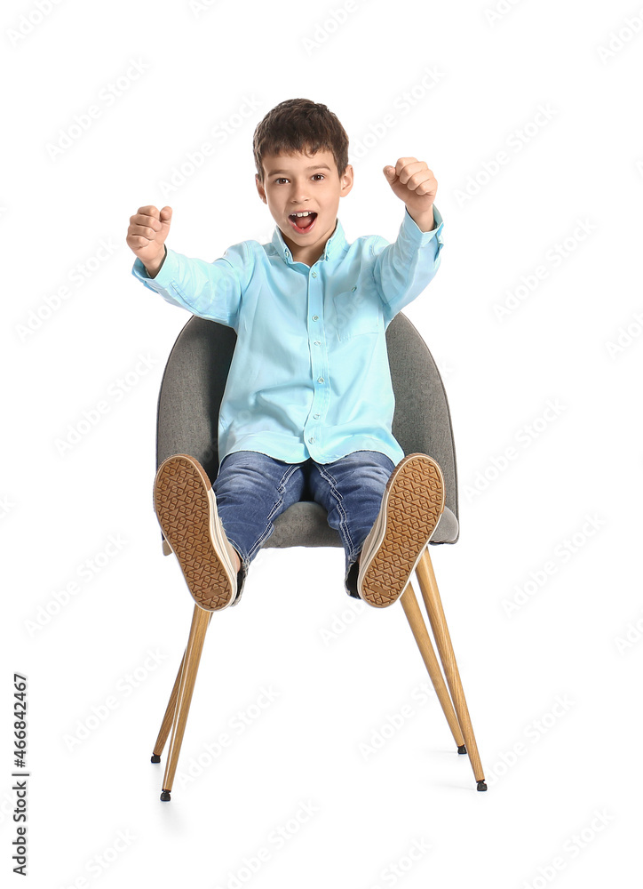 白色背景下坐在椅子上的小男孩，带着想象中的方向盘