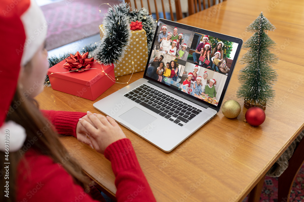 戴着圣诞帽的高加索妇女与不同的朋友和家人进行圣诞笔记本电脑视频通话
