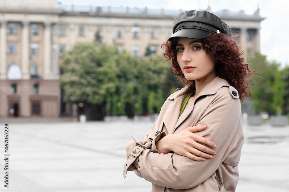 城市广场上戴皮帽的年轻女子扶着肩膀的肖像