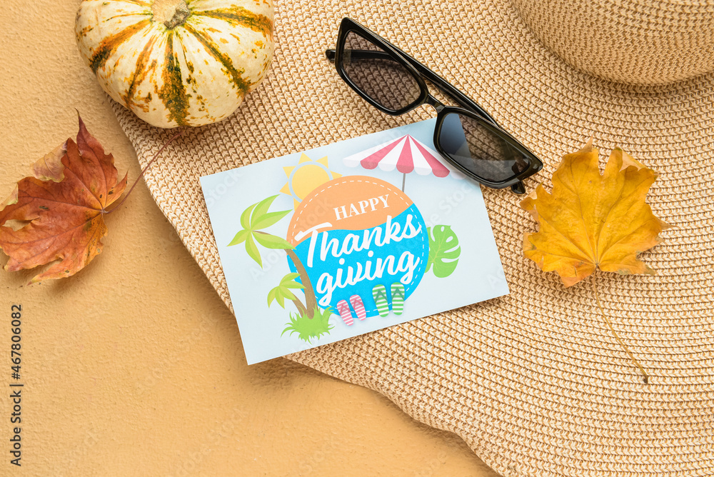 沙滩帽、南瓜、太阳镜、干树叶和纸卡片，背面有祝你感恩节快乐