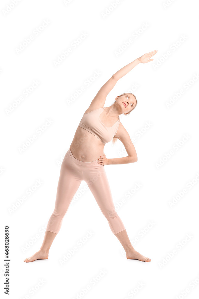 美丽的年轻孕妇在白色背景下练习瑜伽