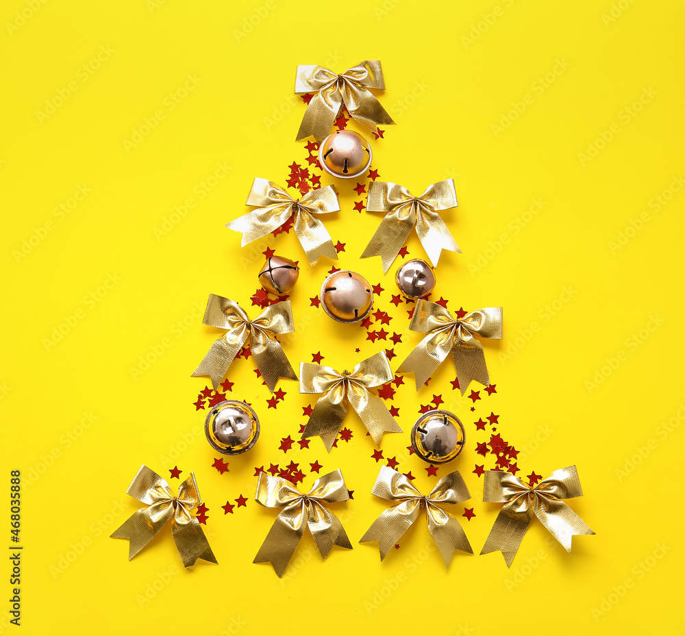 黄色背景的圣诞铃铛和蝴蝶结树