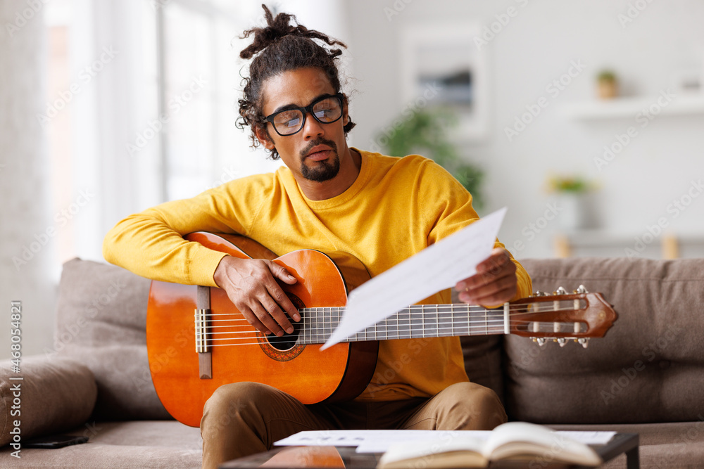 专注于非裔美国男音乐家，用经典原声吉他在纸上阅读乐谱