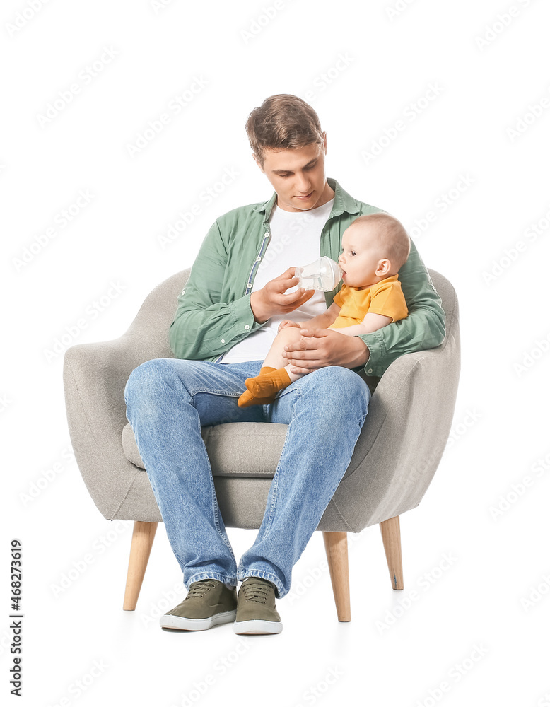 年轻的父亲在白色背景的扶手椅上喂养小婴儿
