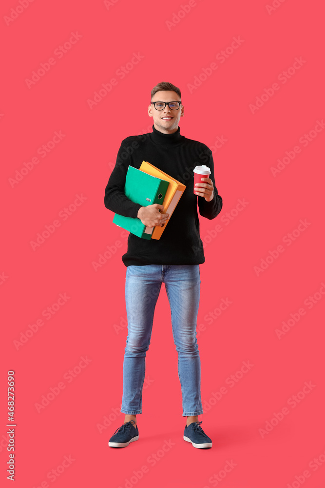 Young man with folders and coffee on color background