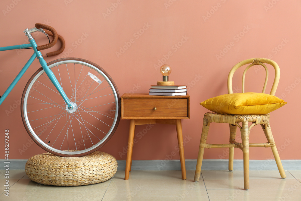 粉红色墙壁附近的桌子、书、椅子和自行车