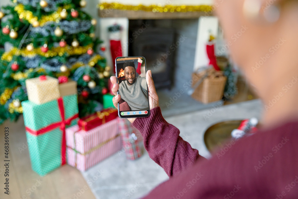 一名女子与微笑的非裔美国男子进行圣诞智能手机视频通话