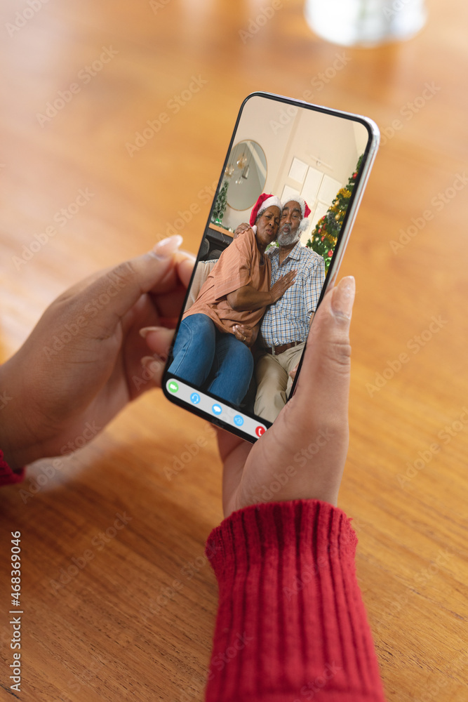 一位女士与一对幸福的非洲裔美国老年夫妇进行圣诞智能手机视频通话