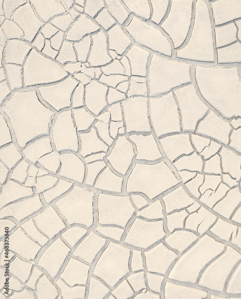 Texture of white cracked clay on dried river bed, vertical natural pattern