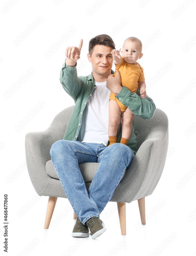 带着小婴儿的年轻父亲指着白色背景上的东西