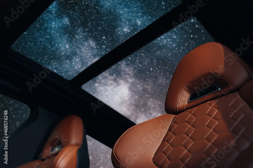 现代跑车的棕色真皮驾驶座头枕，星空下