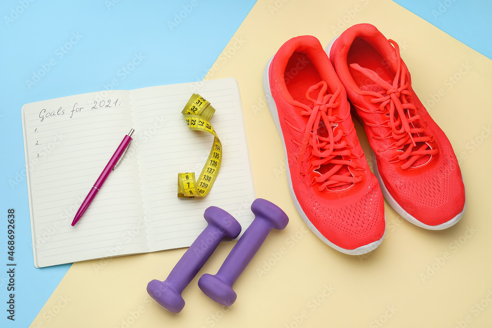 哑铃、鞋子和笔记本，彩色背景上有2021的文字目标