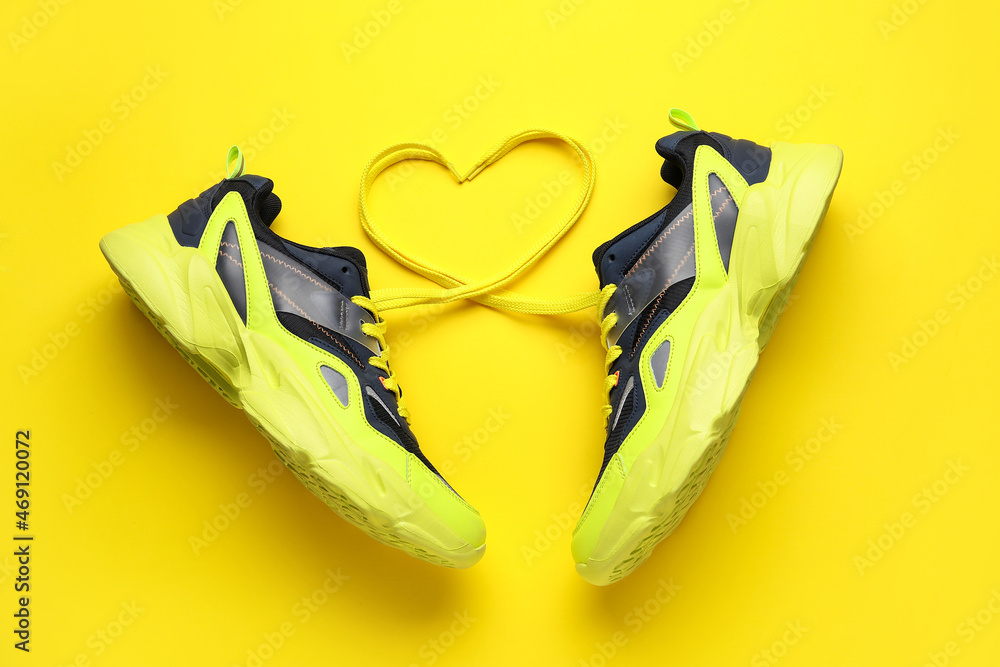 一双运动鞋和彩色背景鞋带制成的心形