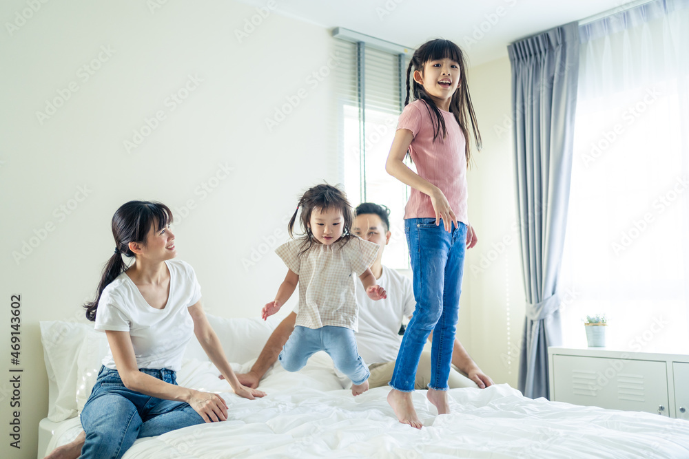 亚洲有趣的家庭很高兴能在家里的床上共度时光。
