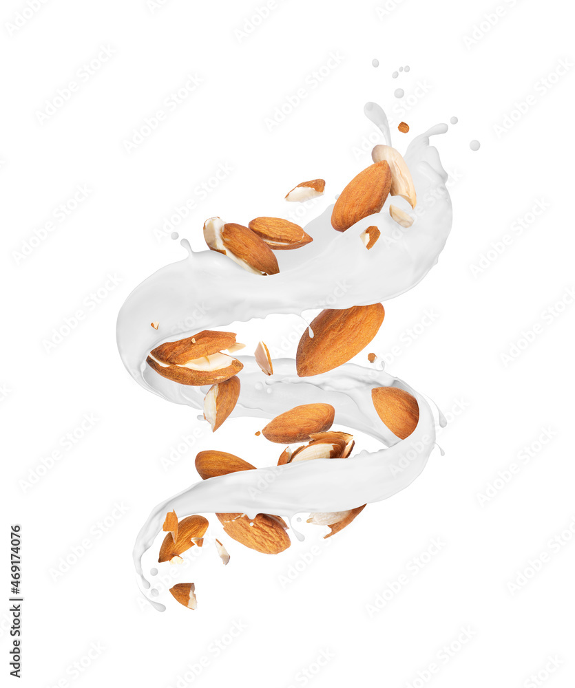 白色背景下螺旋状的牛奶飞溅中的碎杏仁