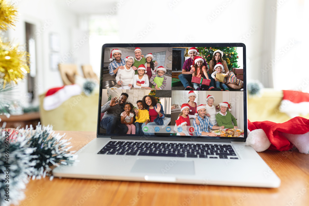 Happy diverse families smiling on laptop group video call screen at christmas time