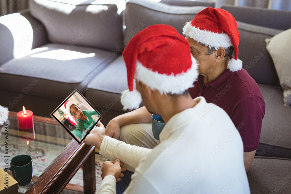 混血父亲和成年儿子与非裔美国男孩进行笔记本电脑圣诞视频通话