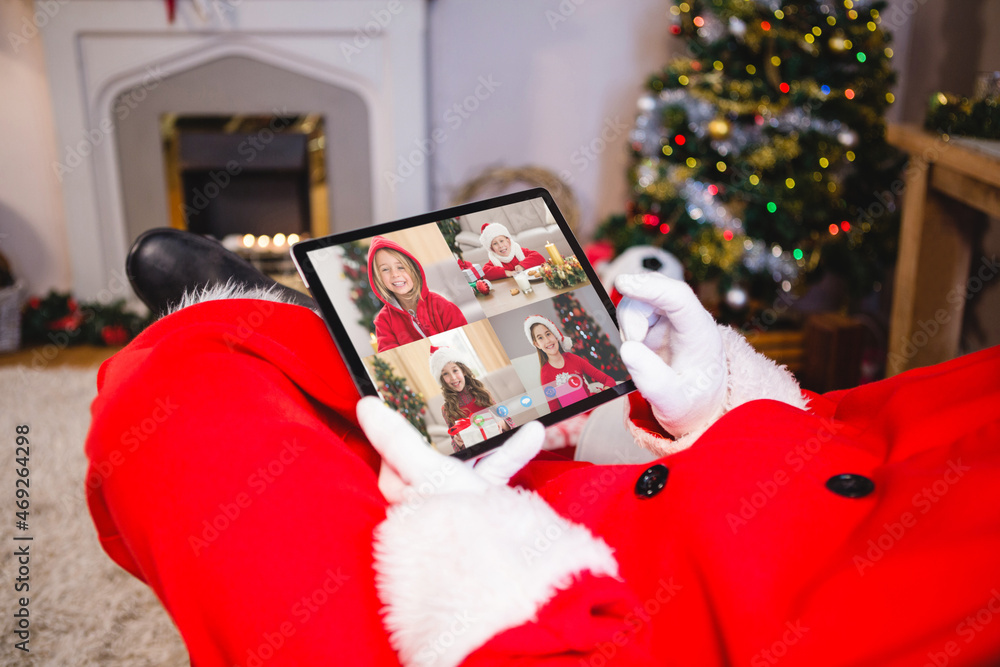 圣诞老人制作平板电脑与戴着圣诞帽微笑的高加索女孩进行圣诞小组视频通话