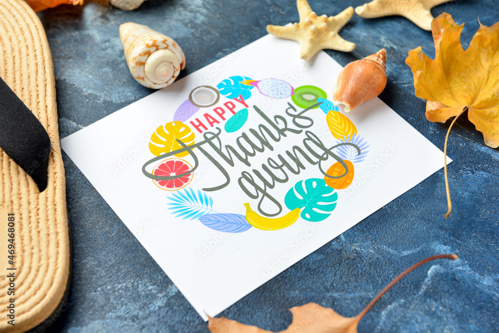Flip flops, seashells, dry leaves and paper card with text HAPPY THANKSGIVING on color background, c