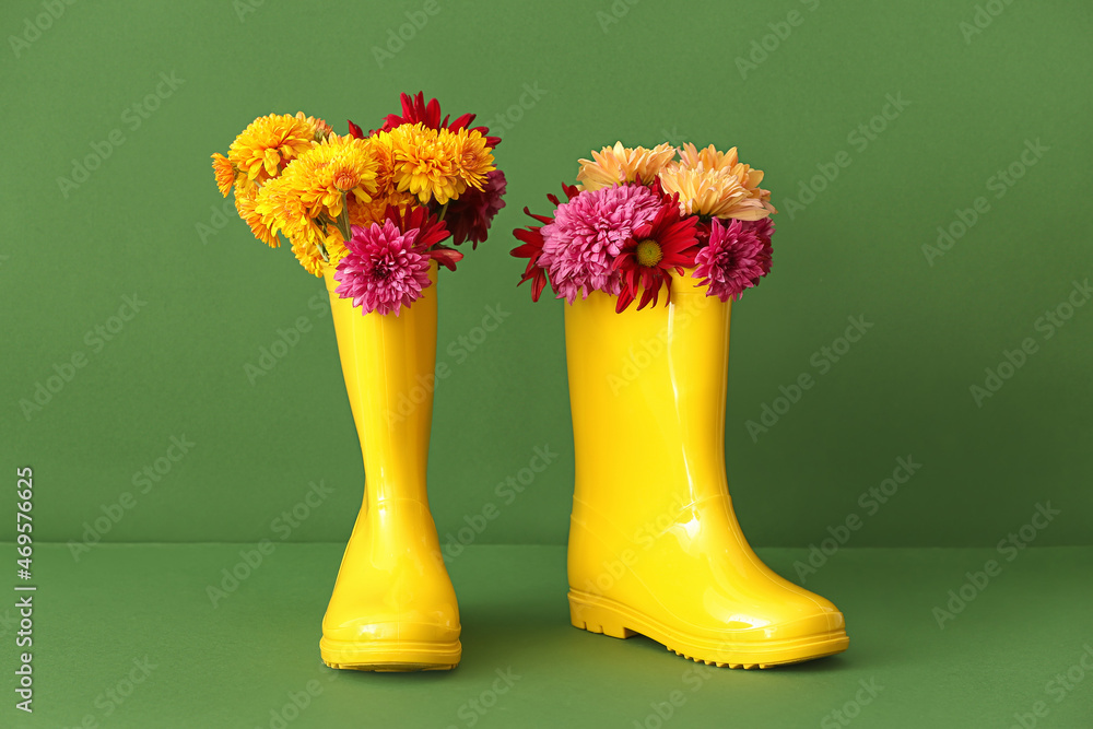一双黄色橡胶靴和彩色背景上的花朵