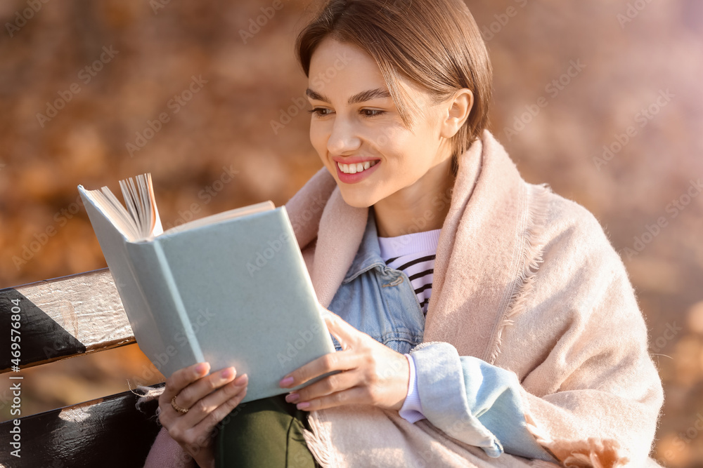 公园木长椅上快乐女人的画像，格子看书