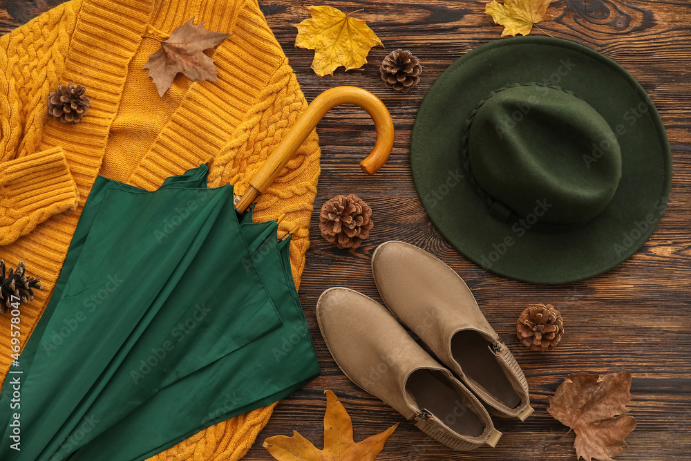 木制背景上的雨伞、鞋子和帽子的秋季构图，特写