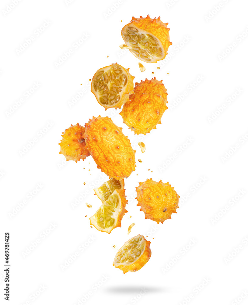Whole and sliced ripe Kiwano melon (Cucumis metuliferus) in the air, isolated on white background