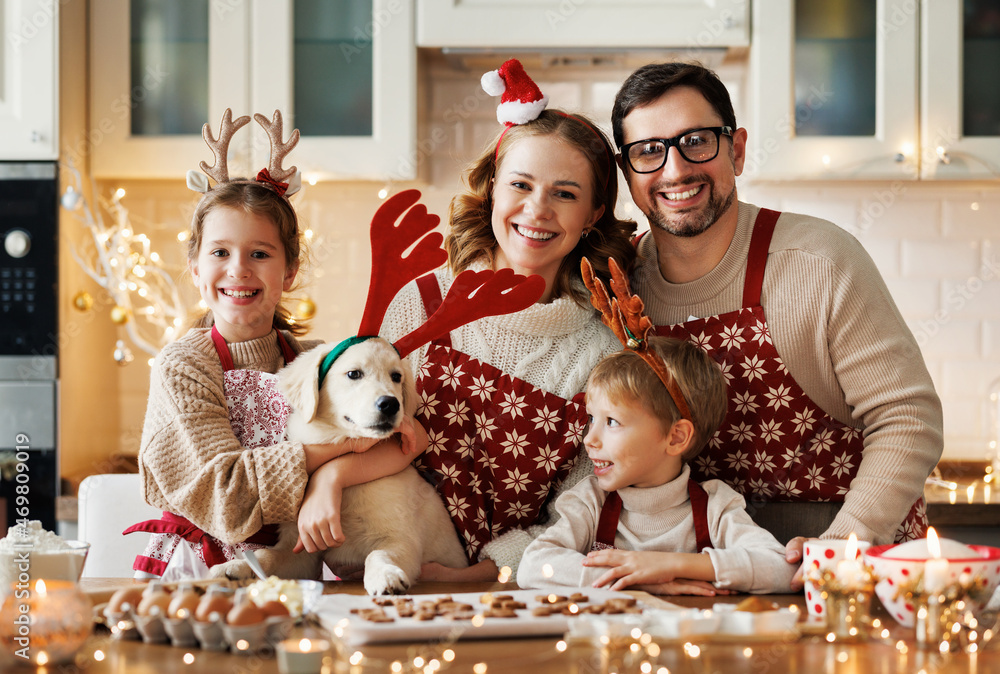有两个孩子和一只金毛寻回犬的快乐家庭父母，在家做圣诞饼干
