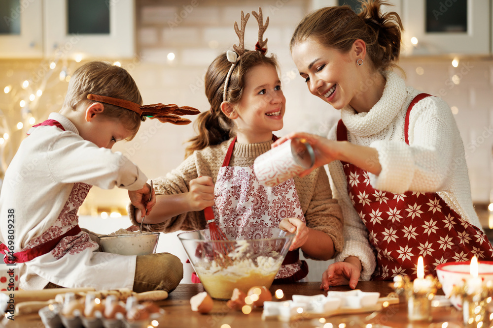 快乐的家庭母亲和两个小孩在家自制圣诞饼干