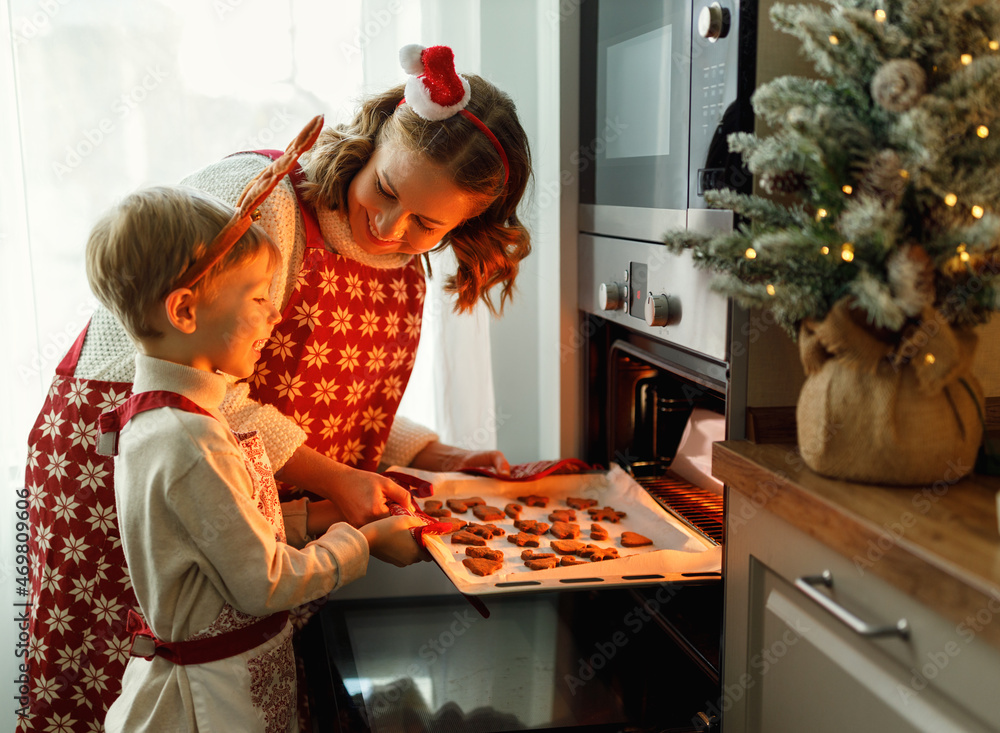 快乐的家庭母子从烤箱里取出新鲜出炉的圣诞饼干