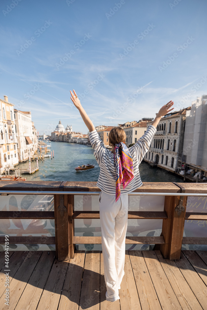 年轻女子从威尼斯学院桥欣赏大运河美景。花钱的想法