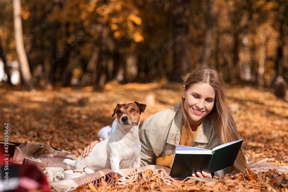 秋天的一天，美丽的女人和杰克·拉塞尔梗在公园看书