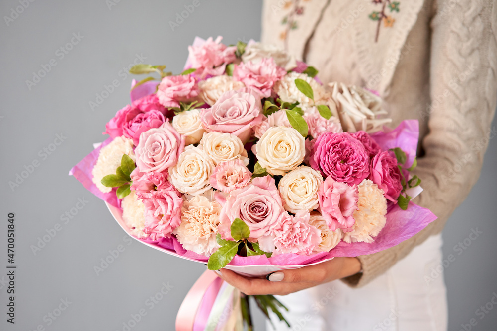 女性手中的混合花朵的美丽花束。花店概念。美丽的新鲜切割花束。