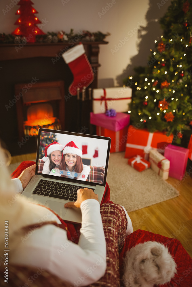 圣诞老人与微笑的高加索母女进行笔记本电脑圣诞视频通话