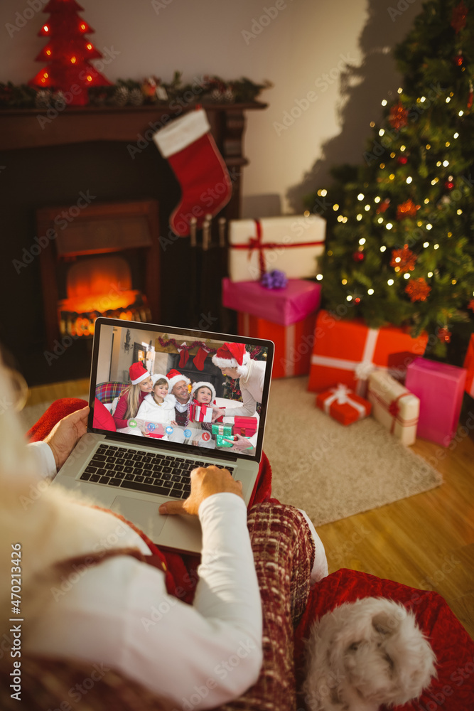 圣诞老人与微笑的高加索家庭进行笔记本电脑圣诞视频通话