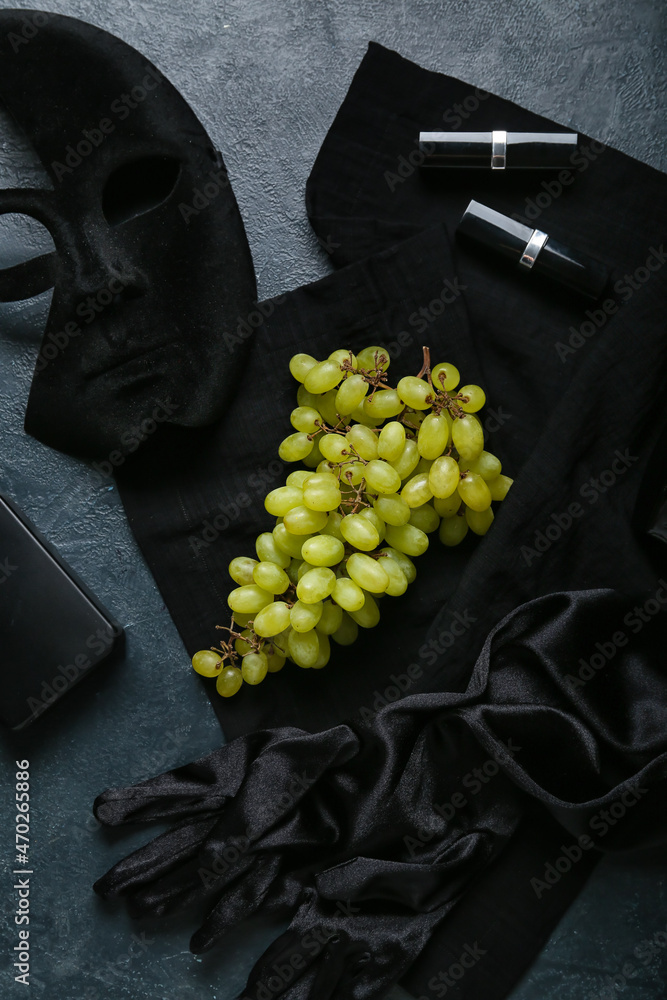 Composition with ripe grapes and female accessories on black background