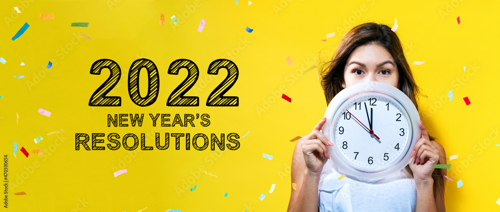 2022年新年决心，年轻女子拿着一个显示近12岁的时钟