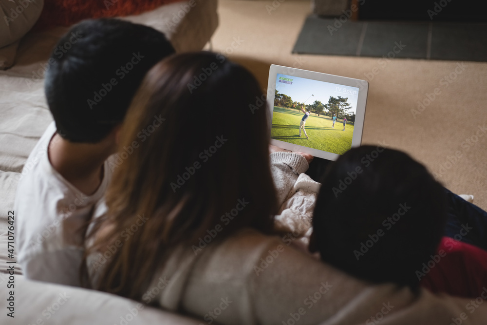 拉丁母亲和孩子在家用笔记本电脑观看高尔夫比赛的背影