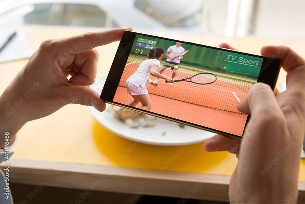 智能手机上餐厅网球比赛中白人男子的手