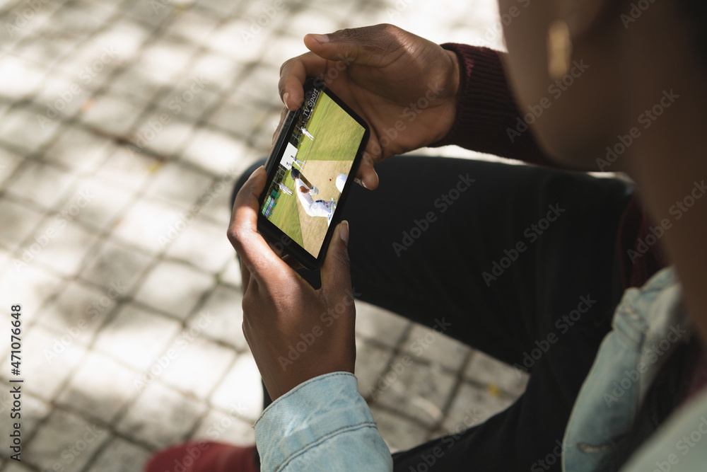 非洲裔美国人在公园里用智能手机看板球比赛
