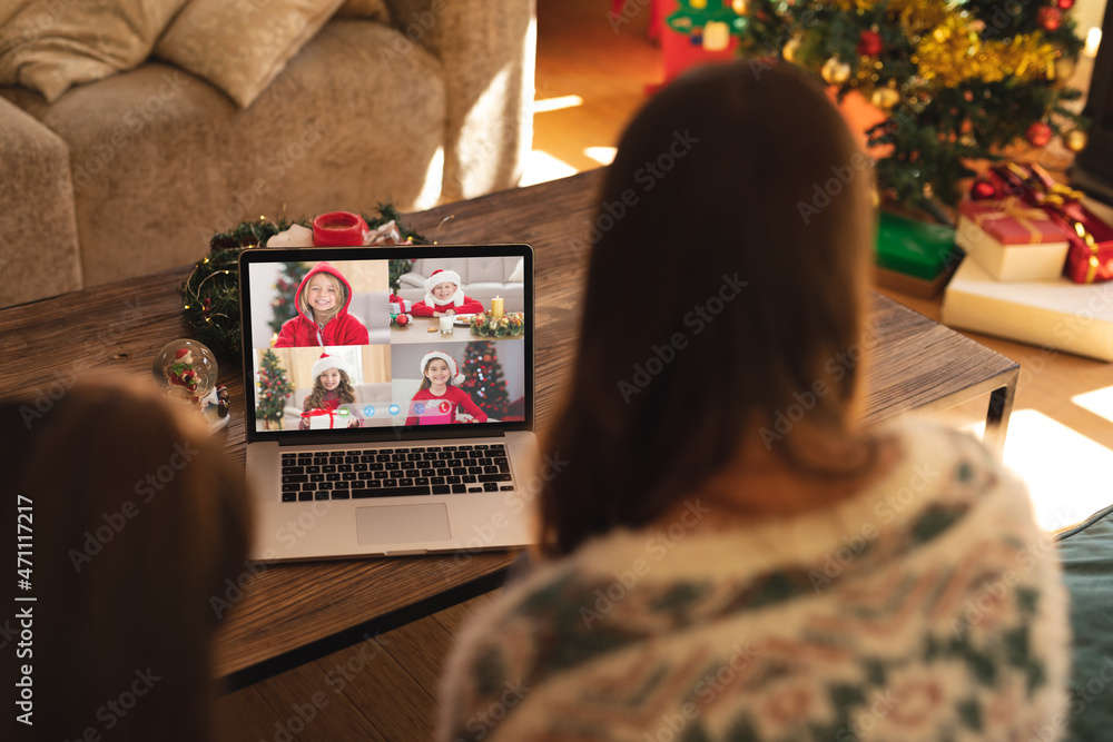 母女俩与四个快乐的高加索女孩进行笔记本电脑圣诞集体视频通话