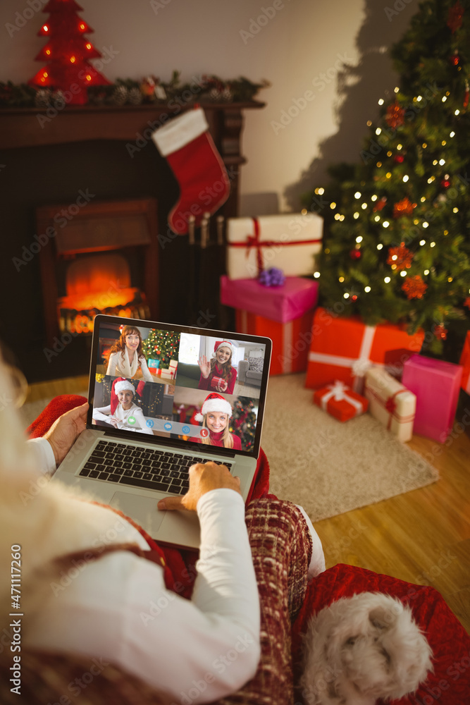 圣诞老人与四位微笑的高加索女性进行笔记本电脑圣诞集体视频通话