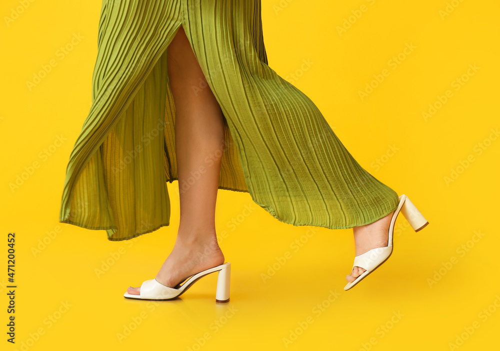 穿着潮鞋走在彩色背景上的女人