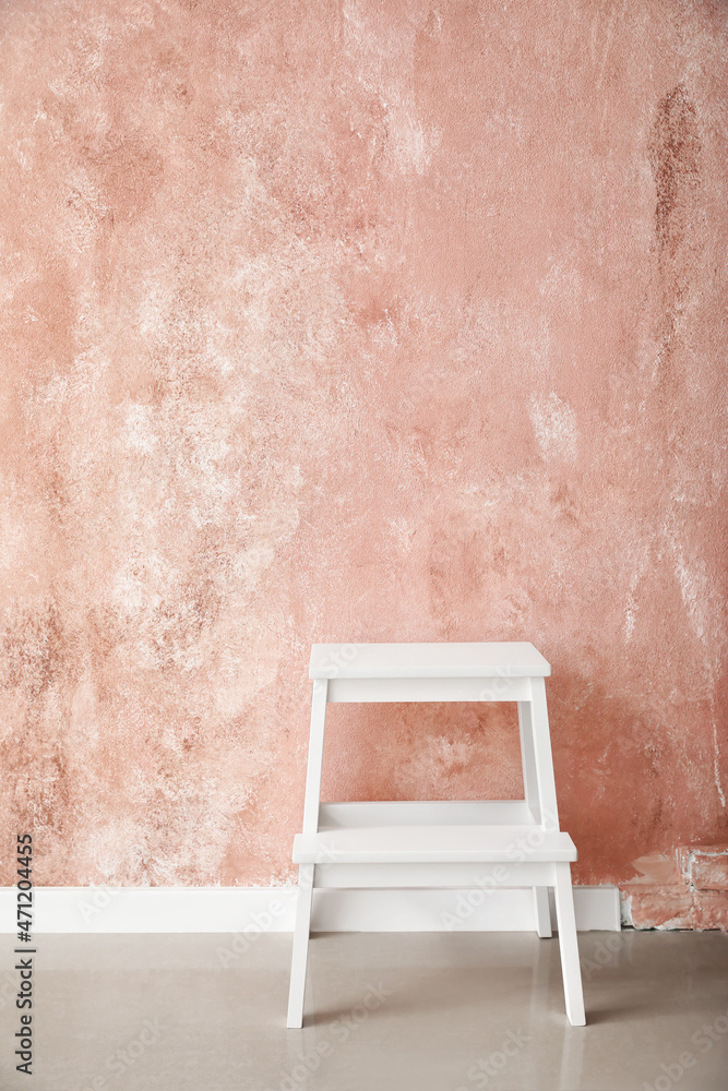 粉色墙壁附近的白色台阶凳