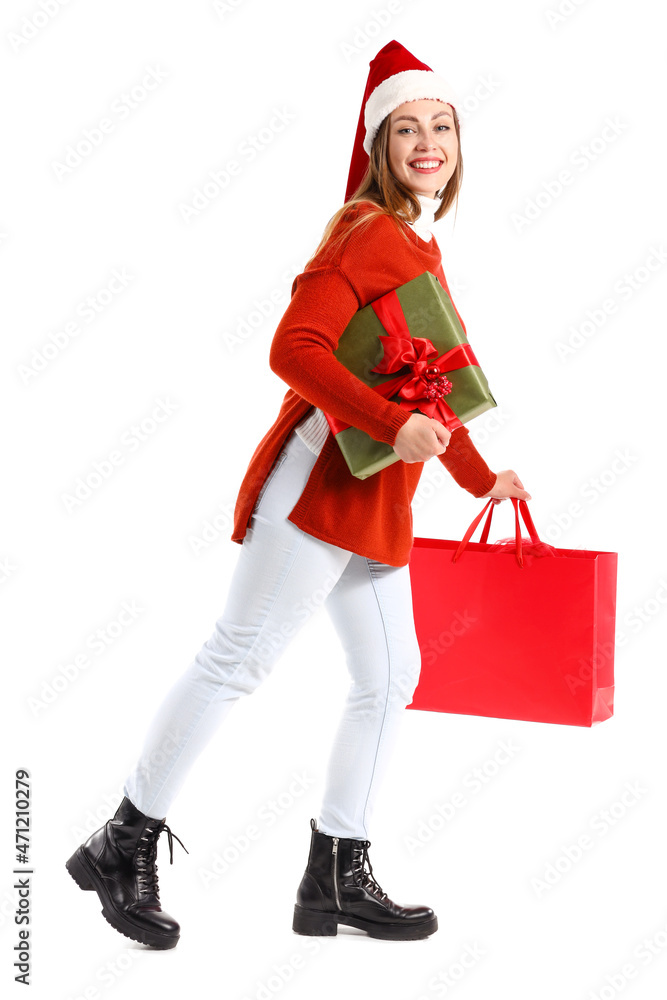 美丽的行走中的年轻女子，白色背景带圣诞礼物和购物袋