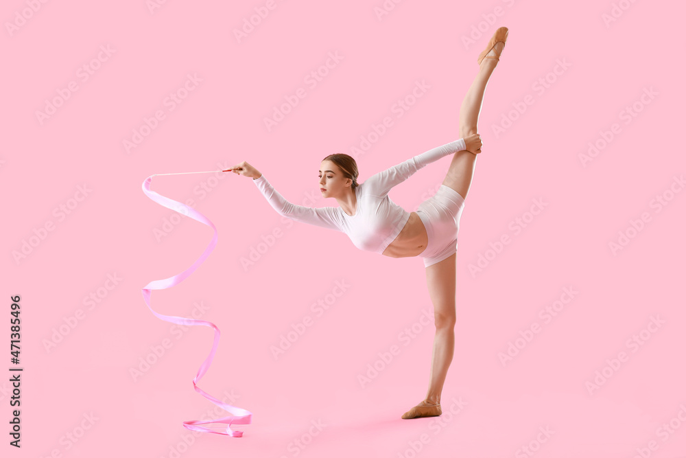 美丽的年轻女子在做体操，彩带背景