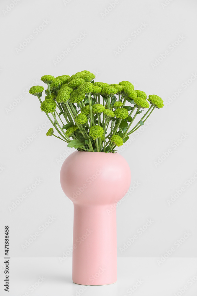 白色背景上有一束绿色菊花的花瓶
