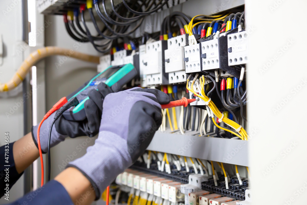 电气工程师测试继电器保护系统上的电气装置和电线。调整