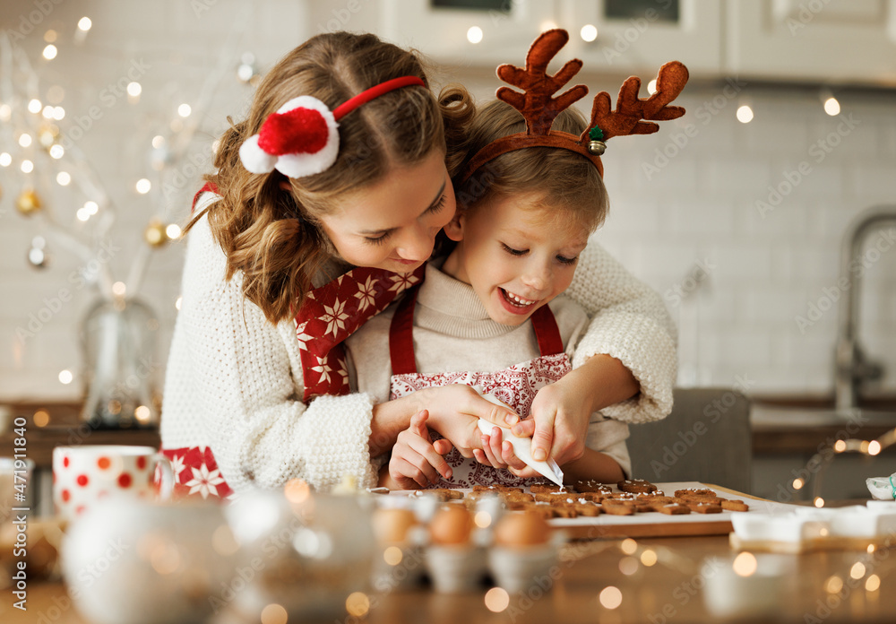 幸福的家庭母亲和儿子穿着围裙在家一起做圣诞饼干